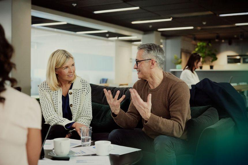 Woman and man talking on the sofa about business. 